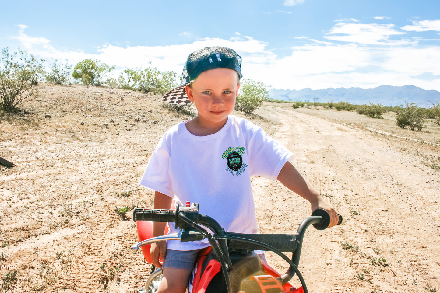 Boy modeling Shred Til Im Dead shirt on dirt bike in white
